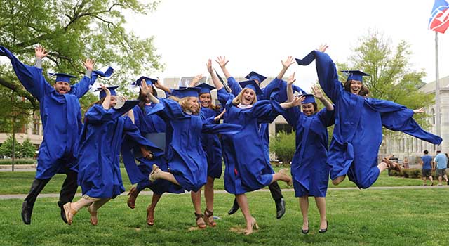ý graduates leap in celebration on the Quad